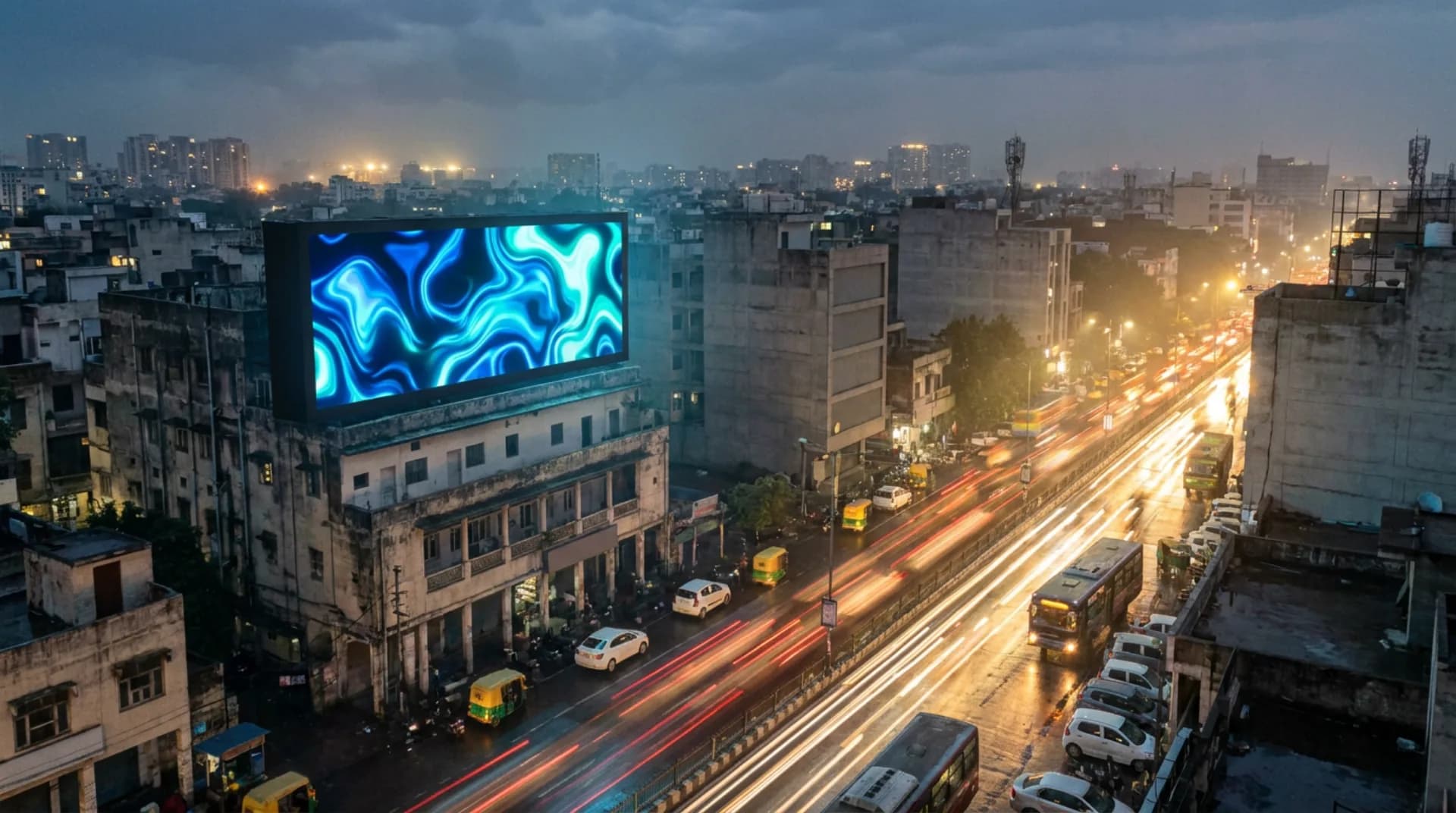 An LED billboard mounted on a building facade at dusk, showing abstract blue light above a busy city street